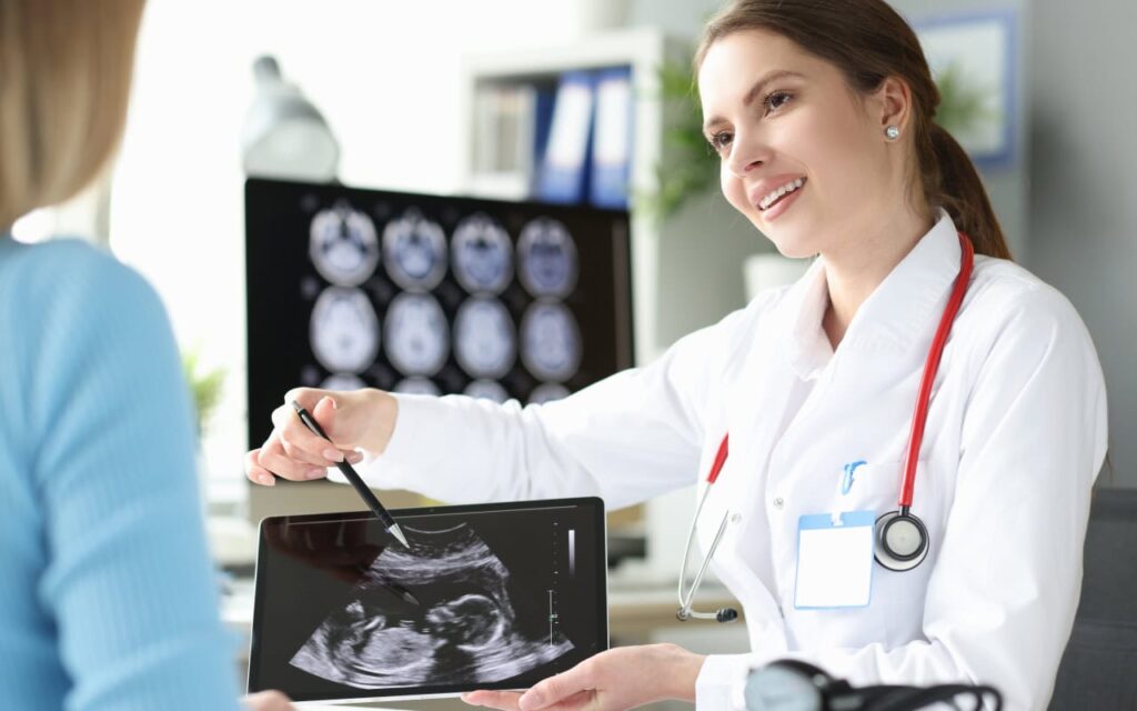 Una doctora sostiene una tableta mientras apunta con su pluma la imagen de un ultrasonido